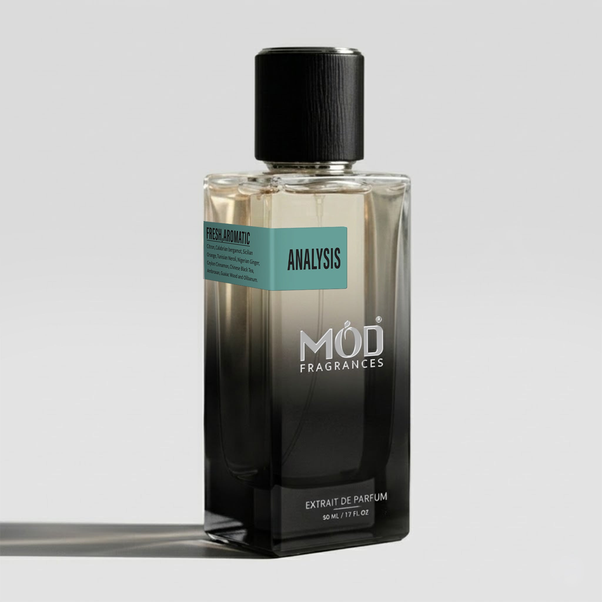A rectangular glass perfume bottle by MOD Fragrances, labeled "Analysis" with a small label detailing its fresh, aromatic notes, stands on a light background.