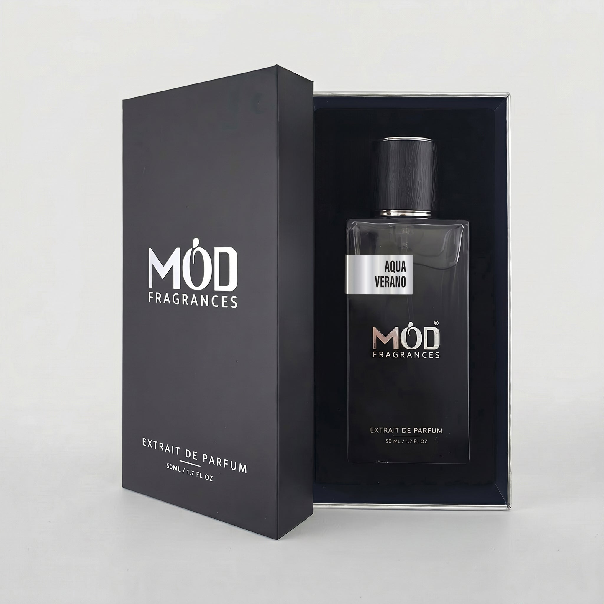 An open black perfume box reveals a rectangular glass bottle labeled "Aqua Verano" by MOD Fragrances, resting securely in a black-lined presentation case. 