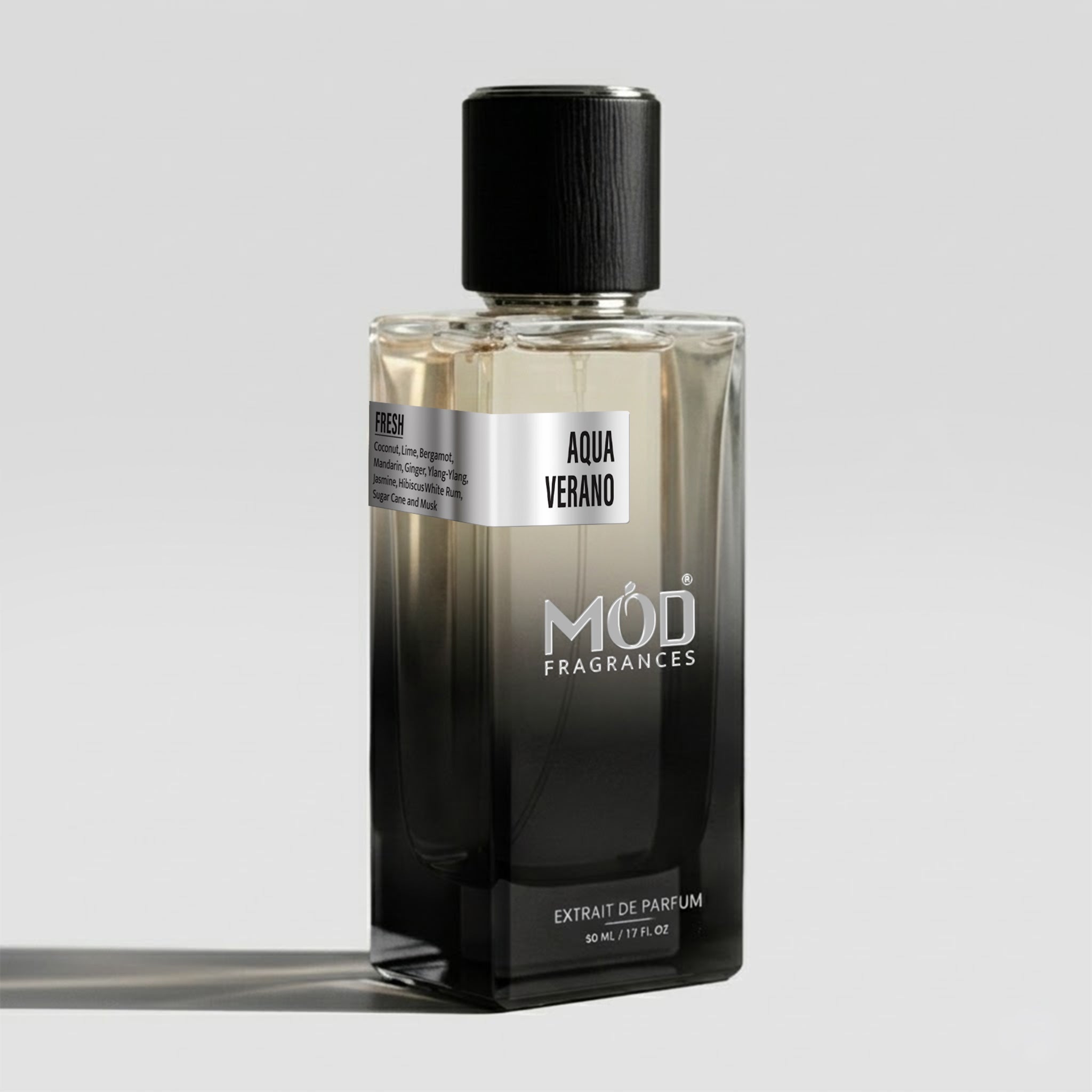 A rectangular glass perfume bottle by MOD Fragrances, labeled "Aqua Verano" with a small label detailing its leather, woody notes, stands on a light background.