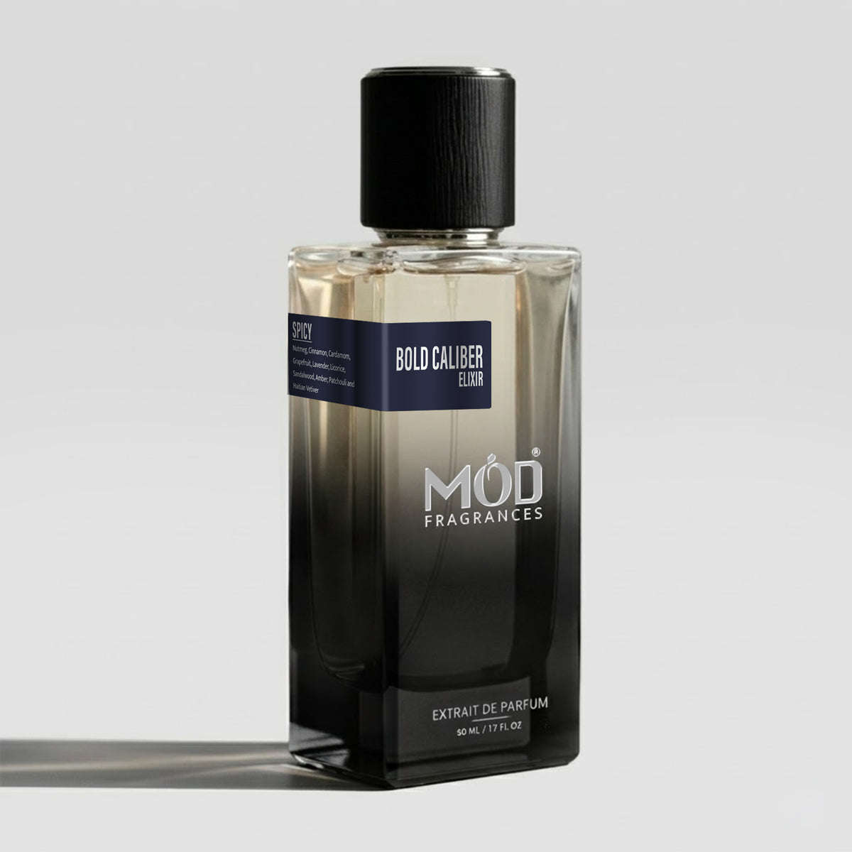 A rectangular glass perfume bottle by MOD Fragrances, labeled “Bold Caliber Elixir” with a small label detailing its notes, stands on a light background.