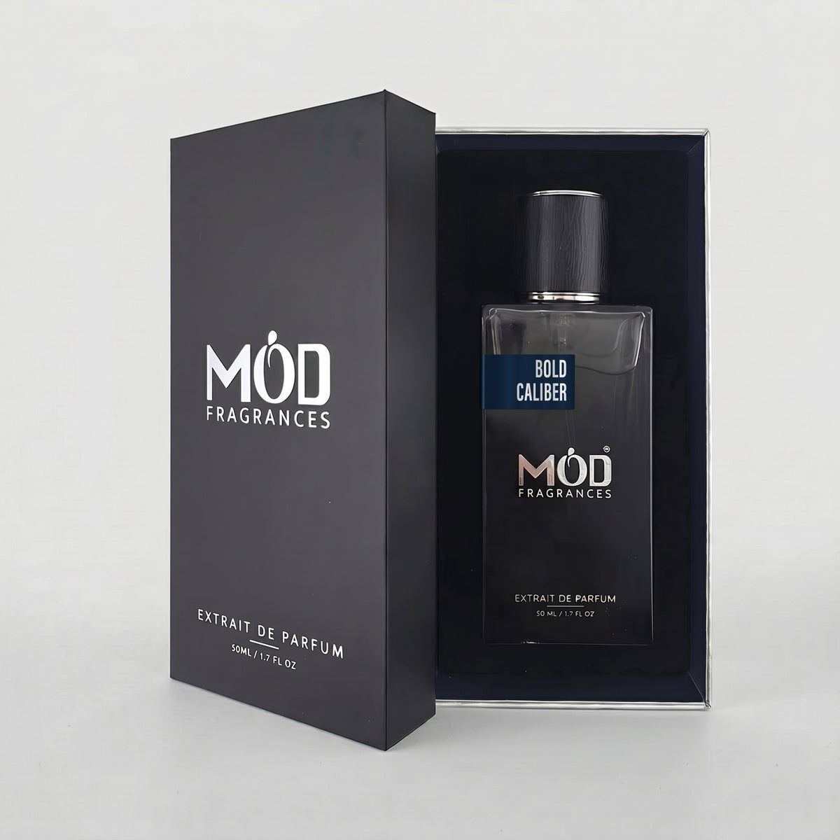 An open premium black perfume box reveals a rectangular glass bottle labeled “Bold Caliber” by MOD Fragrances, resting securely in a black-lined presentation case.