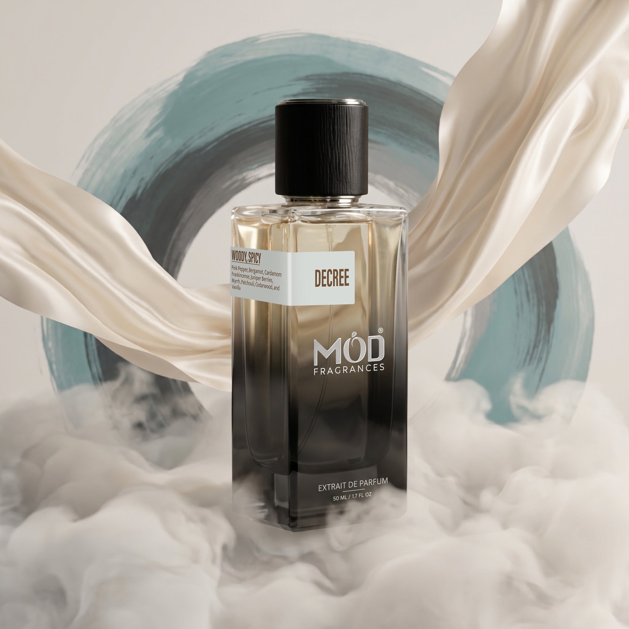A bottle of MOD FRAGRANCES 'Decree' Eau de Parfum stands centered against a stylized background with flowing cream fabric, soft white smoke, and a blue-gray painted circle. The bottle is clear glass with dark amber-to-black liquid and a black cap.