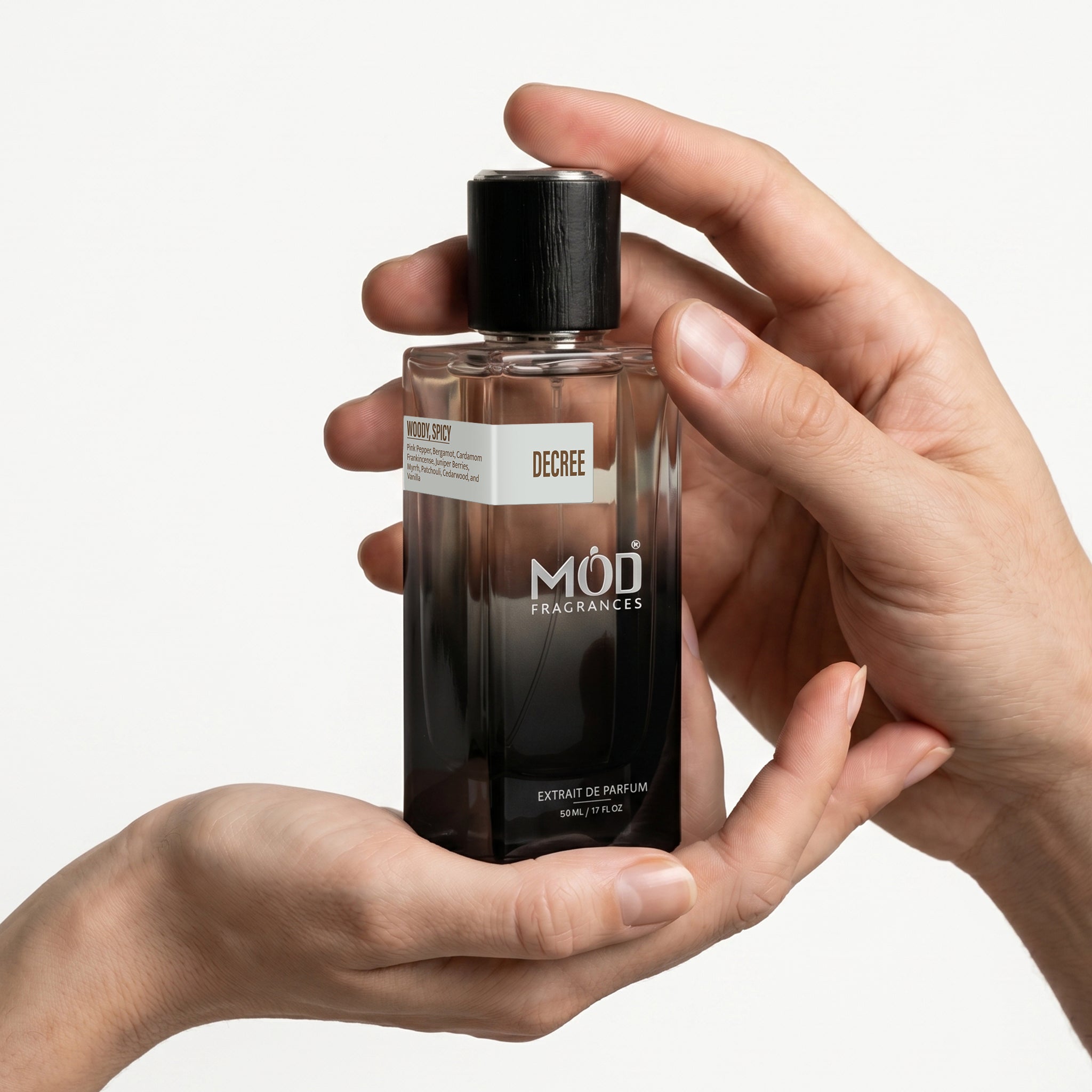 Person holding a MOD Fragrances perfume bottle with a plain background