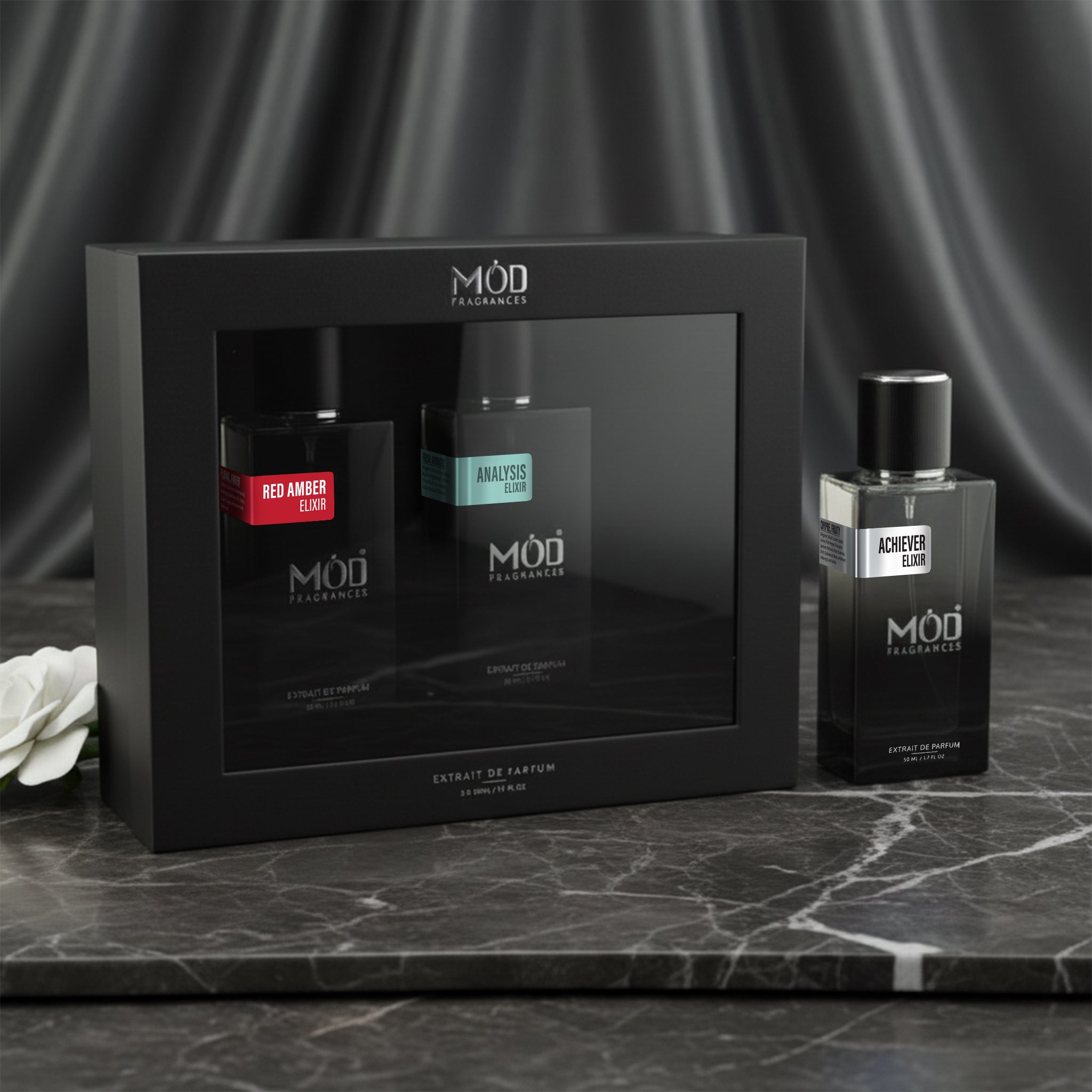 Möd perfume bottles and packaging on a dark surface with a gray curtain background