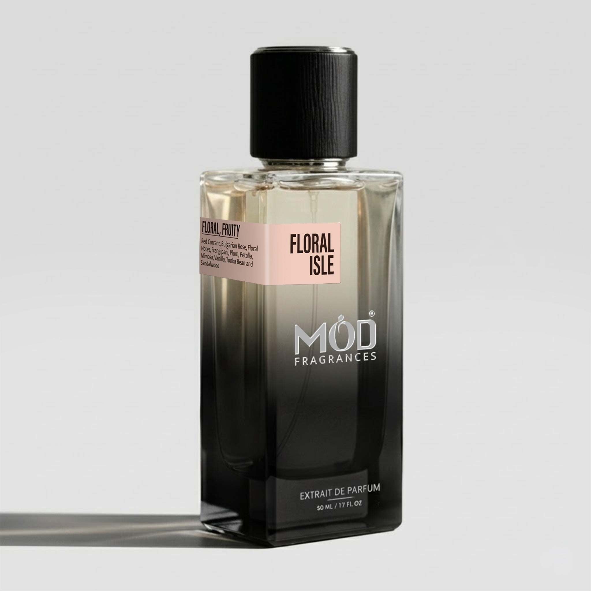 A rectangular glass perfume bottle by MOD Fragrances, labeled “Floral Isle” with a small label detailing its notes, stands on a light background.