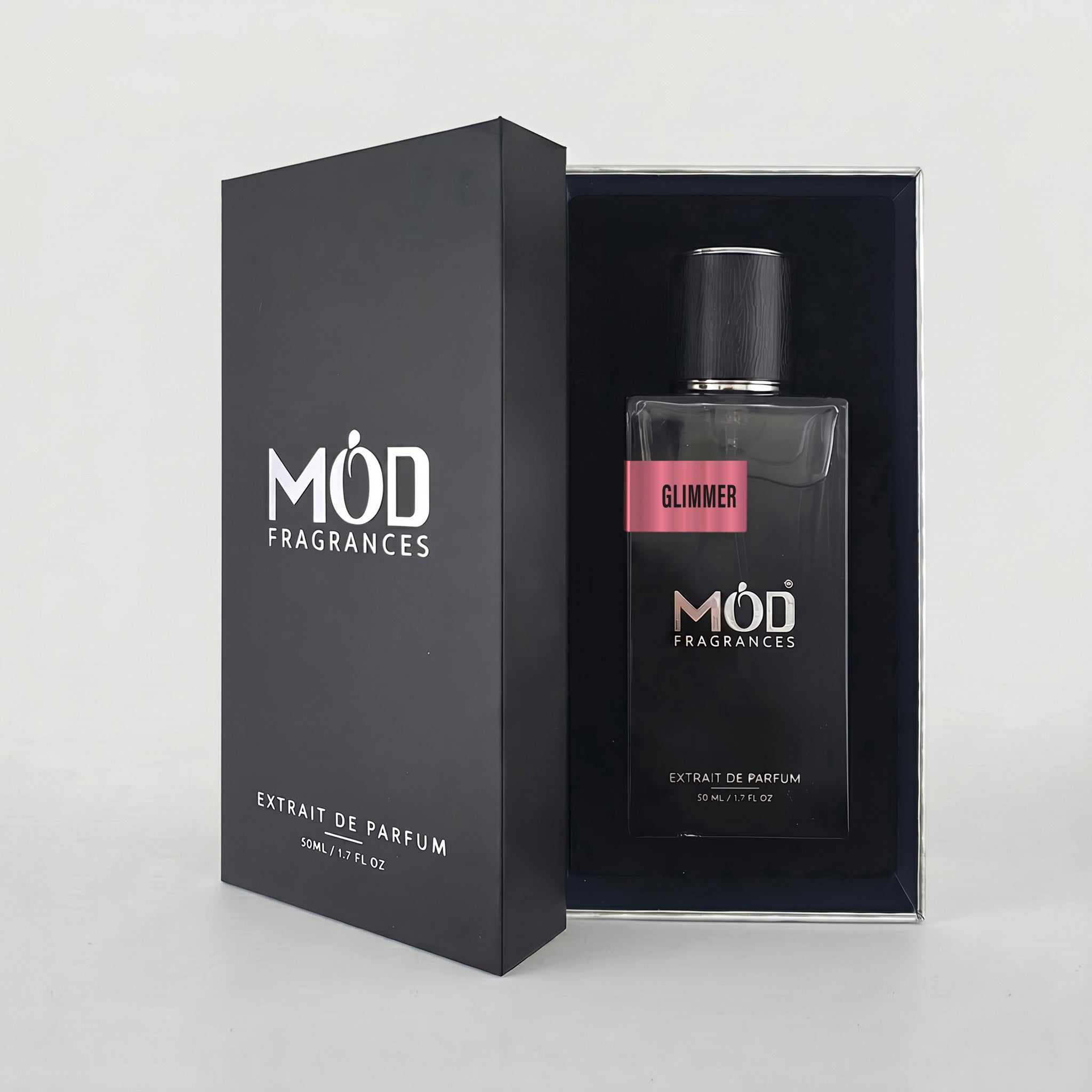 An open premium black perfume box reveals a rectangular glass bottle labeled “Glimmer” by MOD Fragrances, resting securely in a black-lined presentation case.