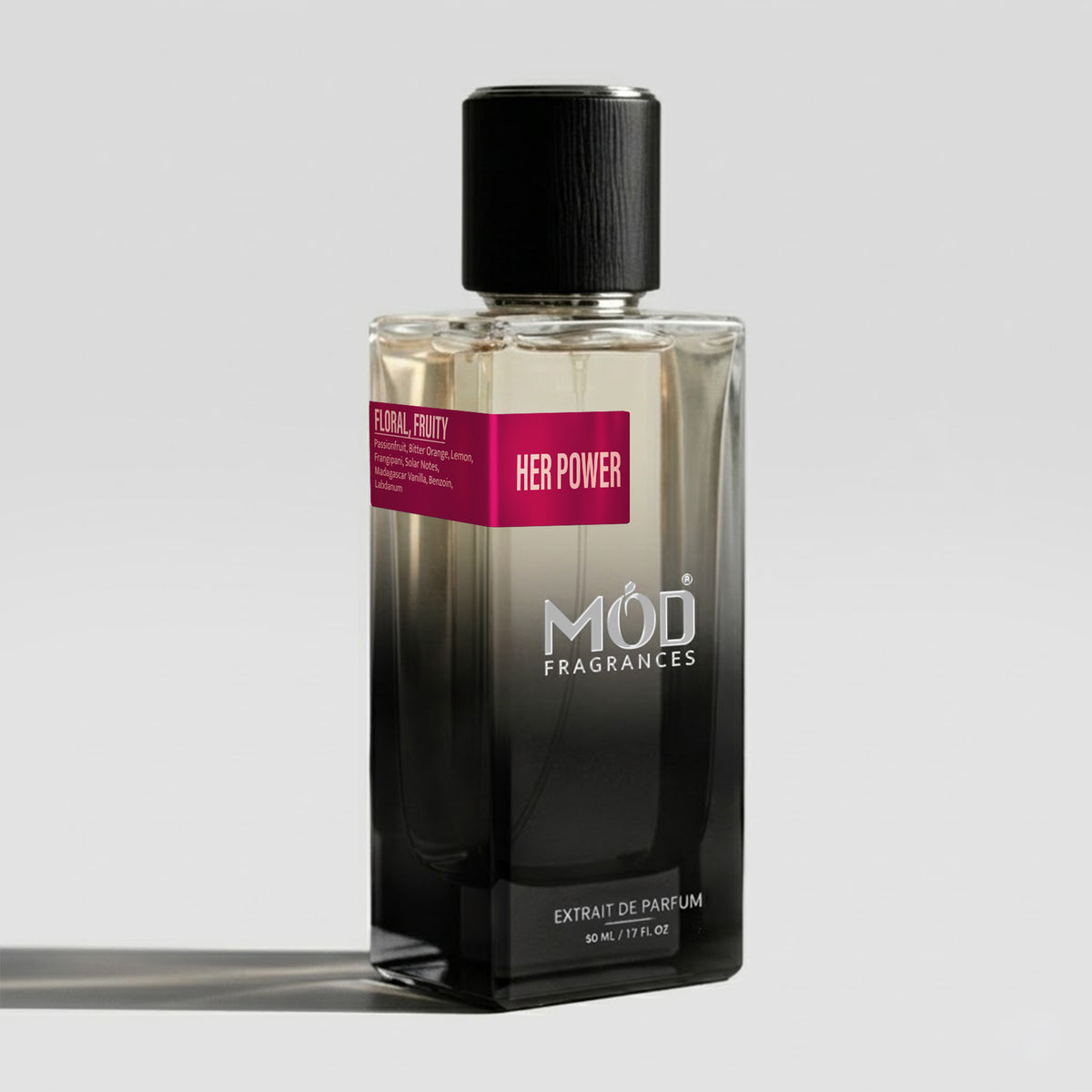 A bottle of Mod Fragrances 'Her Power' Extrait de Parfum, featuring a black-to-clear gradient glass bottle with a black cap and a pink label, set against a light gray background.