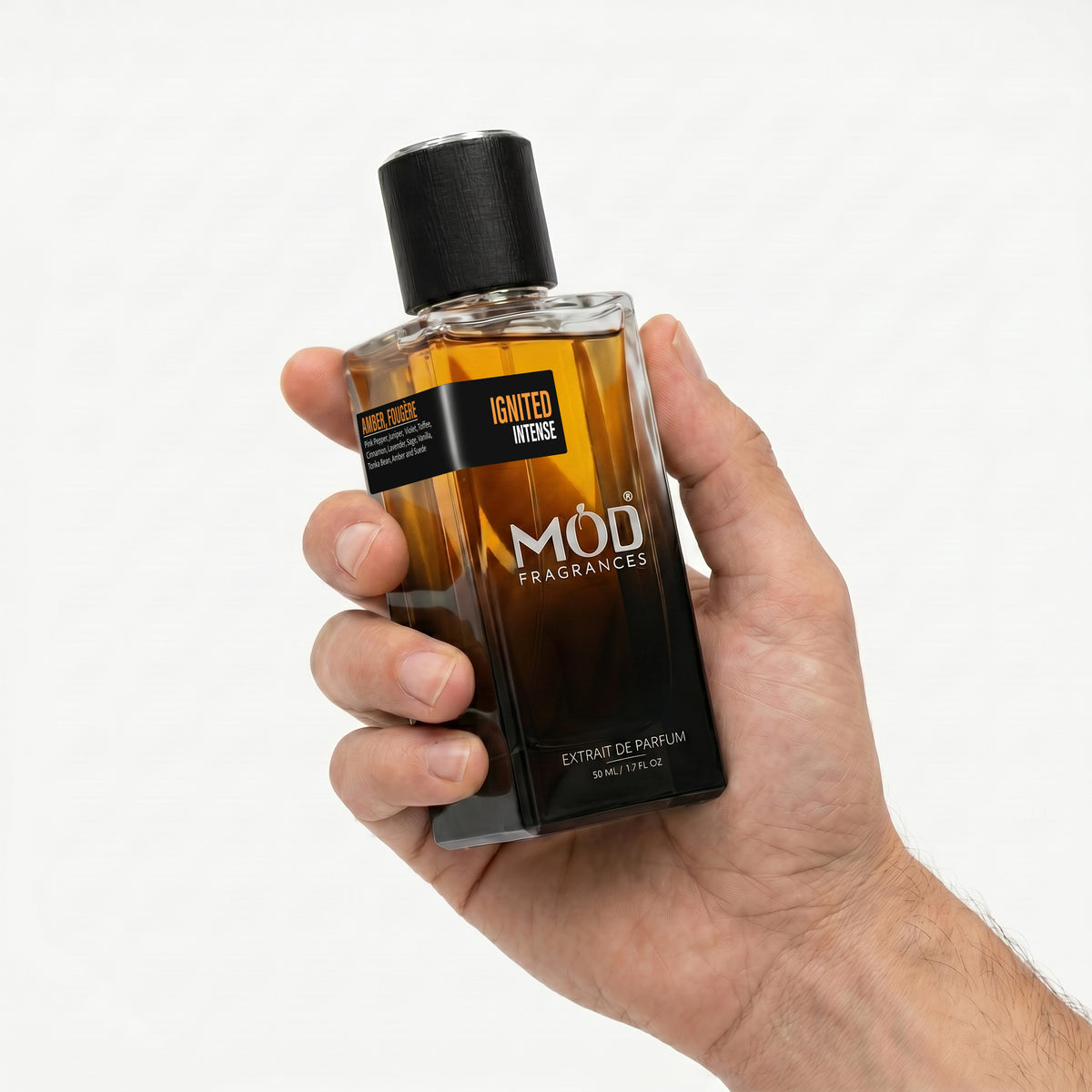 A hand holding a bottle of Mod Fragrances Ignited Intense Extrait de Parfum against a clean white background.