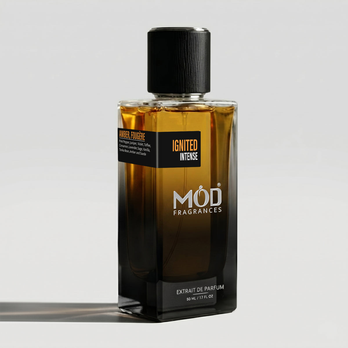 A bottle of MOD Fragrances 'Ignited Intense' parfum extract de parfum, featuring a dark amber-brown gradient glass bottle with a black cap and black label, set against a light gray background.
