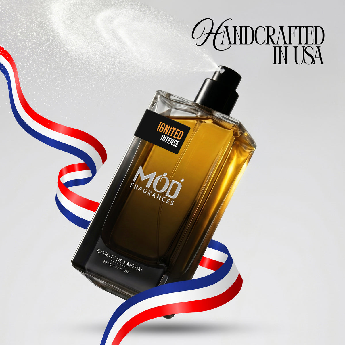 A bottle of MOD FRAGRANCES 'Ignited Intense' perfume spray, shown at an angle with a black spray nozzle emitting a white mist. The bottle is filled with amber-colored liquid and has a black label.