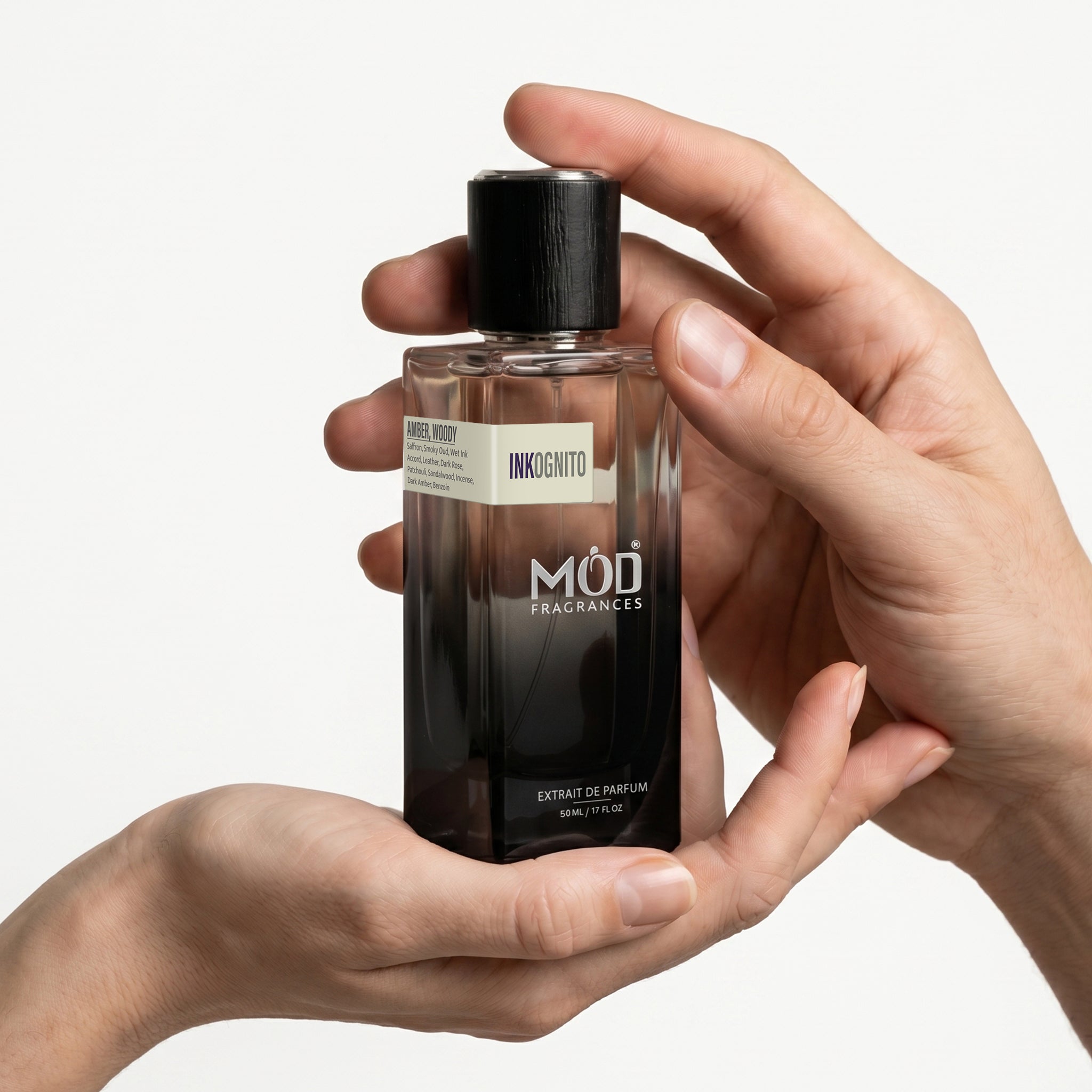 Person holding a MOD Fragrances perfume bottle, for him, for her, with a plain background
