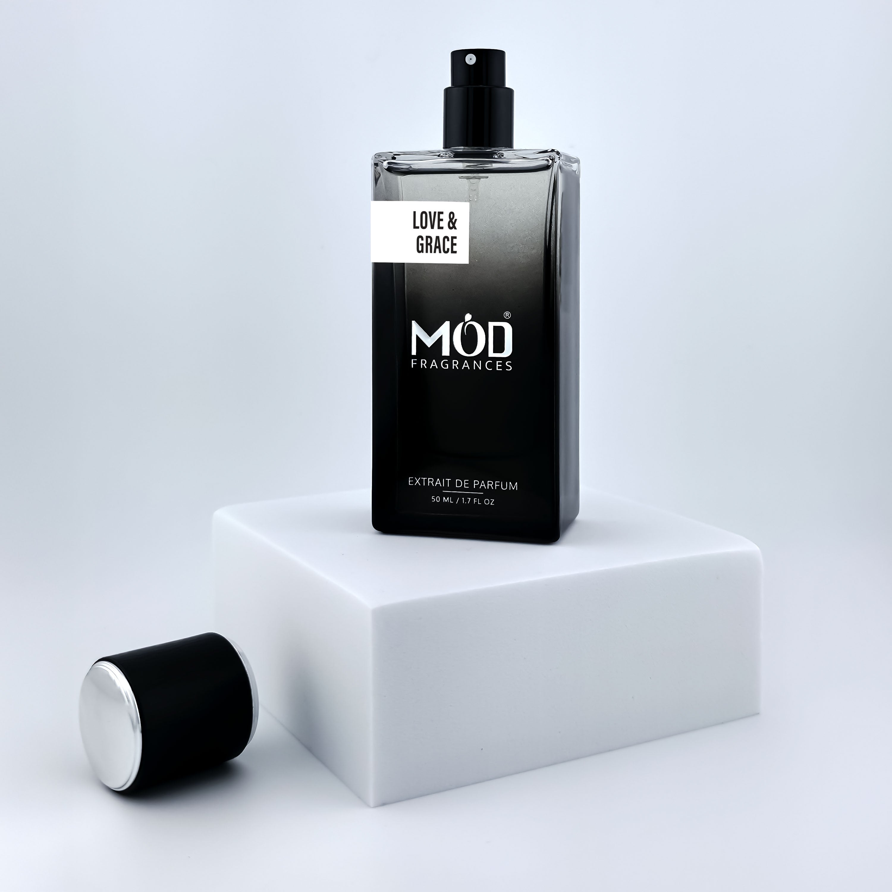Perfume bottle labeled 'Love & Grace' by MOD Fragrances on a white platform with a light gray background