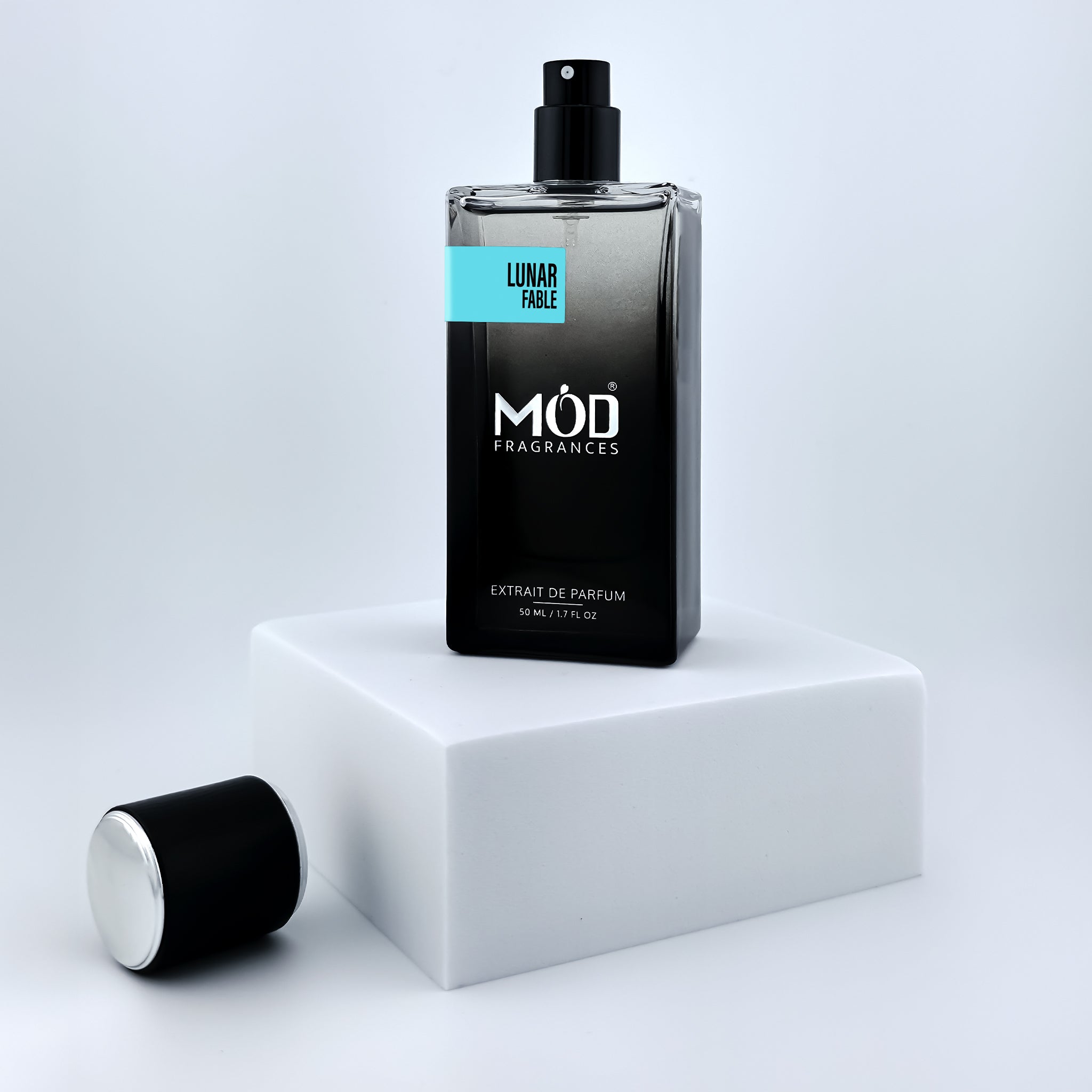 Black perfume bottle with 'Möd Fragrances' on a white platform against a light gray background