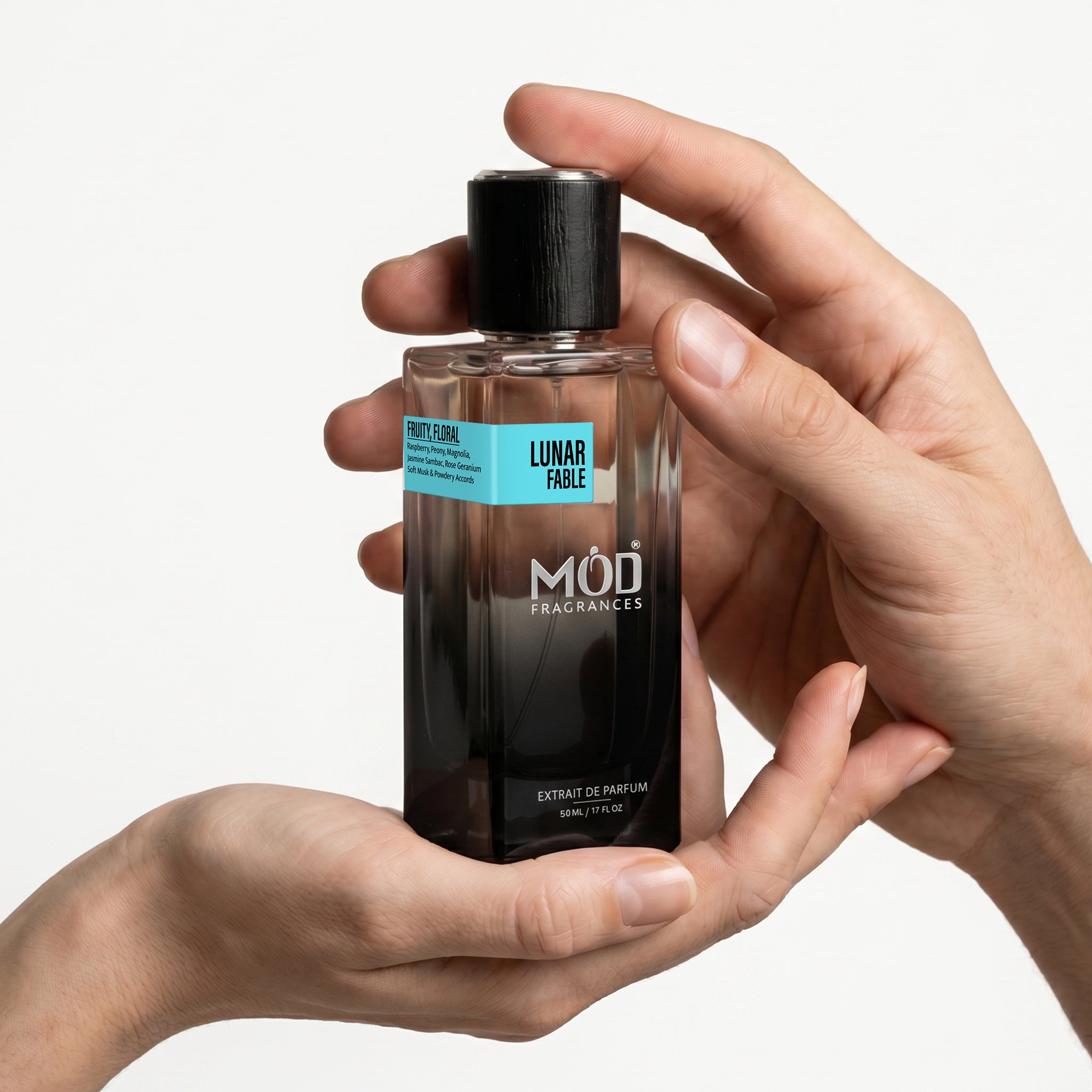 MOD Fragrances 50ml perfume bottle "Lunar Fable" floral fruity fragrance for unisex, inspired by Moon Tale, on white background. for him, for her, one male and one female hand holding perfume bottle 
