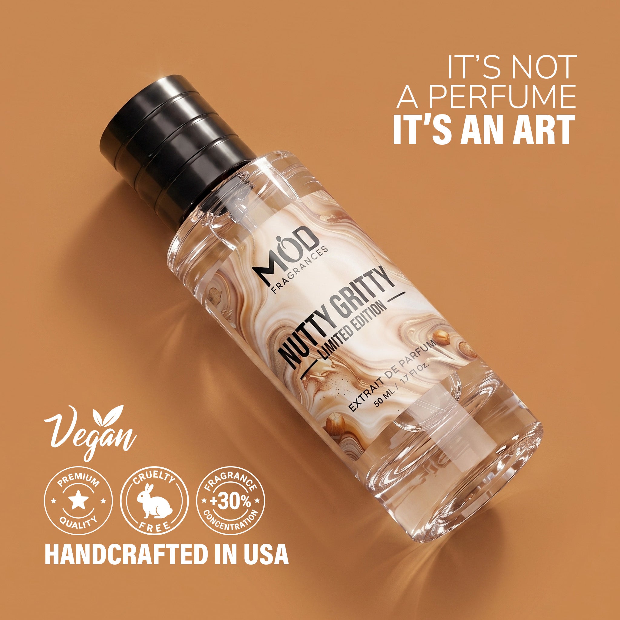 A clear cylindrical bottle with a black cap and a cream-and-brown marbled label reading 'MOD Fragrances' and 'Nutty Gritty - Limited Edition,' shown on a warm tan background with promotional text and badges.