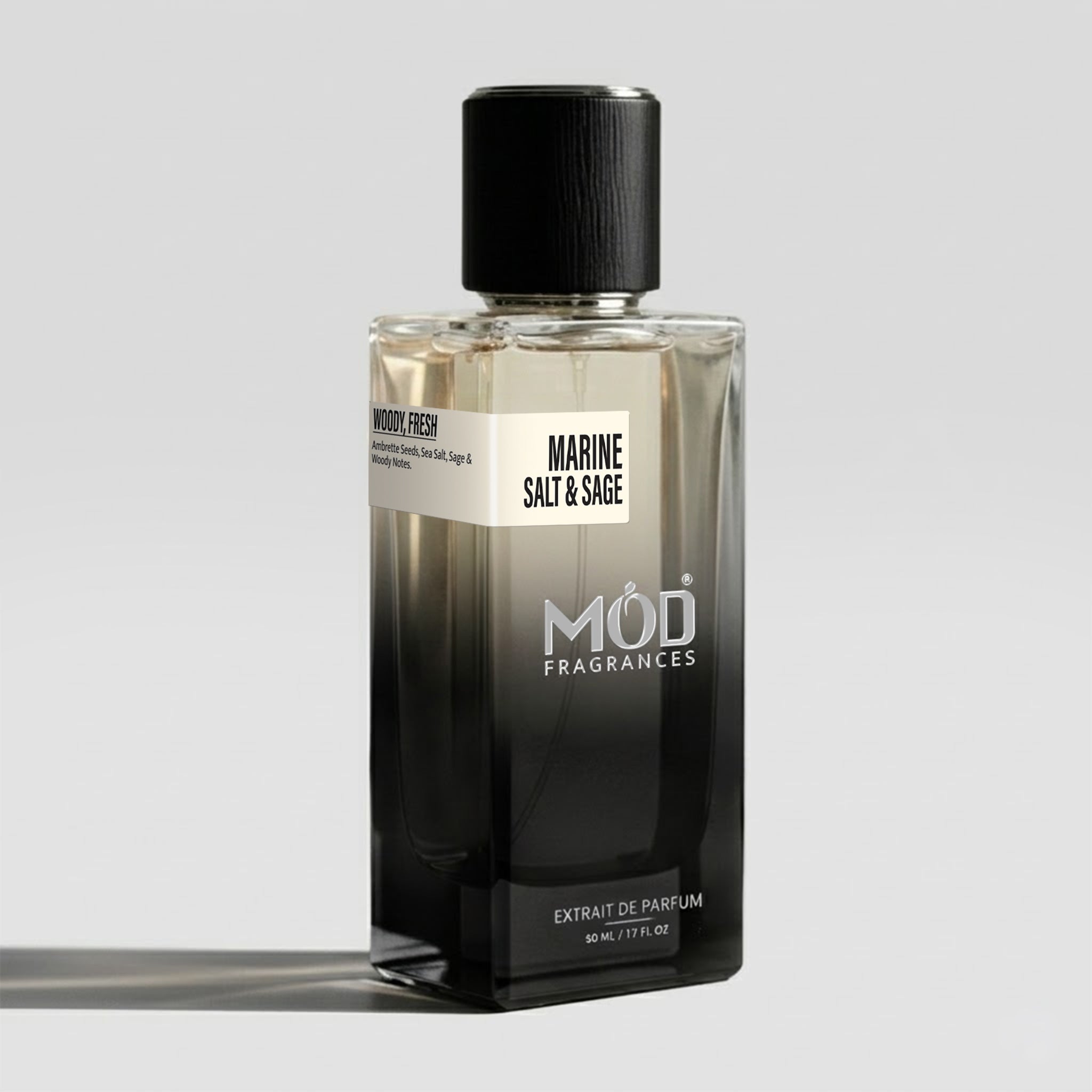 A bottle of MOD Fragrances Marine Salt & Sage Extrait de Parfum, featuring a black-to-clear gradient glass bottle with a black cap, set against a light gray background.