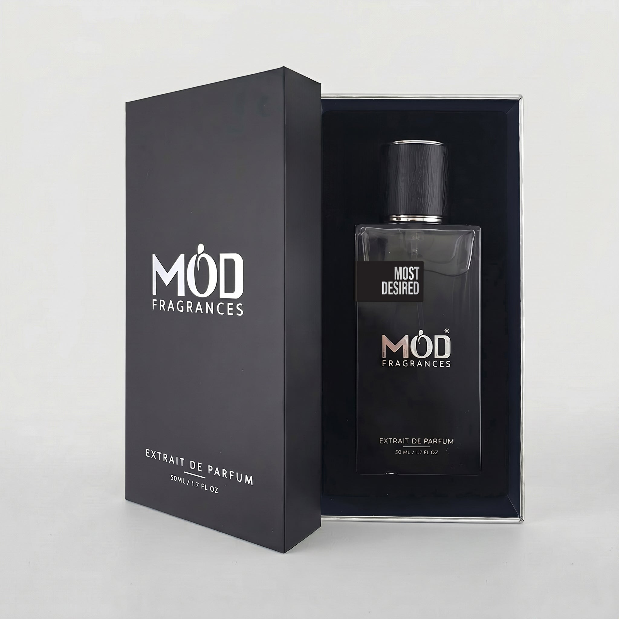 An open premium black perfume box reveals a rectangular glass bottle labeled “Most Desired” by MOD Fragrances, resting securely in a black-lined presentation case.