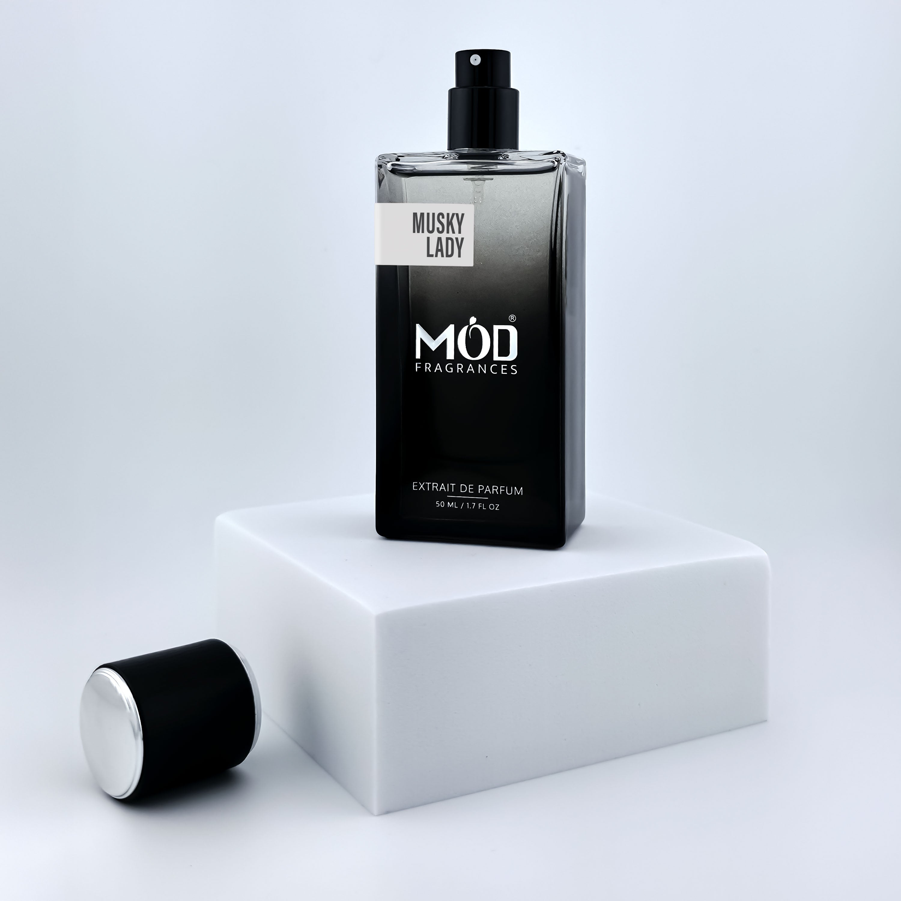 Perfume bottle labeled 'Musky Lady by MOD Fragrances on a white platform with a light gray background