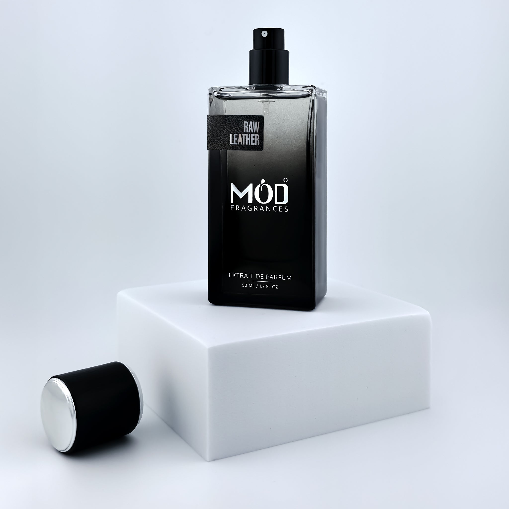 Black perfume bottle with 'Möd Fragrances' on a white platform