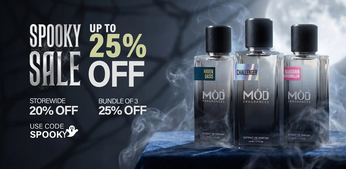 Three MOD Fragrances bottles displayed on a dark draped surface with smoke effects, alongside promotional sale text reading 'Spooky Sale up to 25% off' and additional discount details.