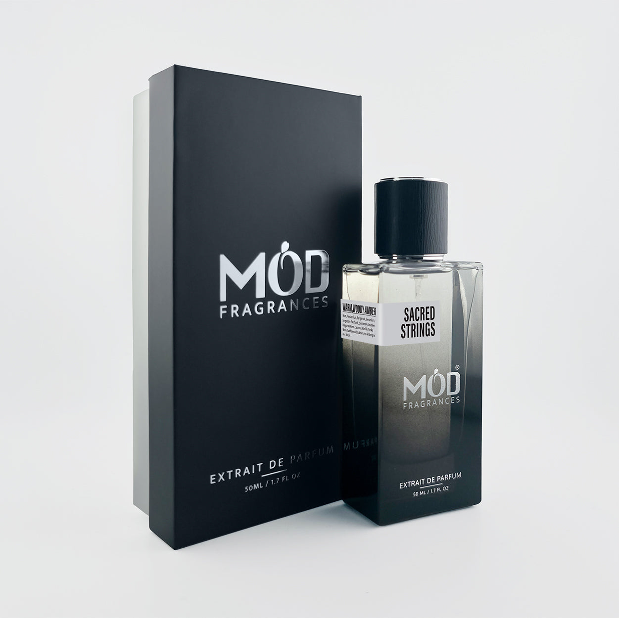 A bottle of MOD Fragrances Sacred Strings Extrait de Parfum next to its black packaging box, set against a clean light gray background.