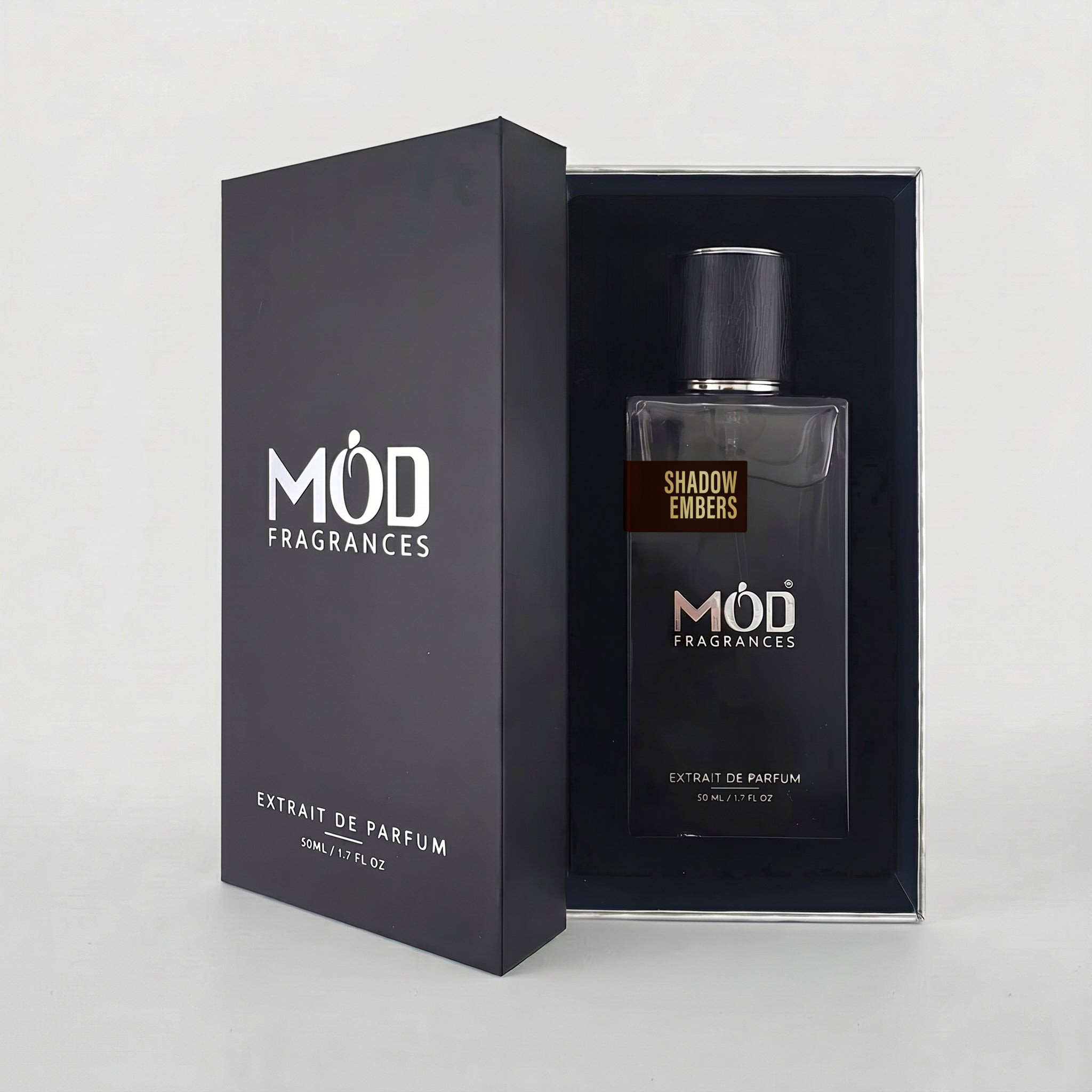 An open premium black perfume box reveals a rectangular glass bottle labeled “Shadow Embers” by MOD Fragrances, resting securely in a black-lined presentation case.