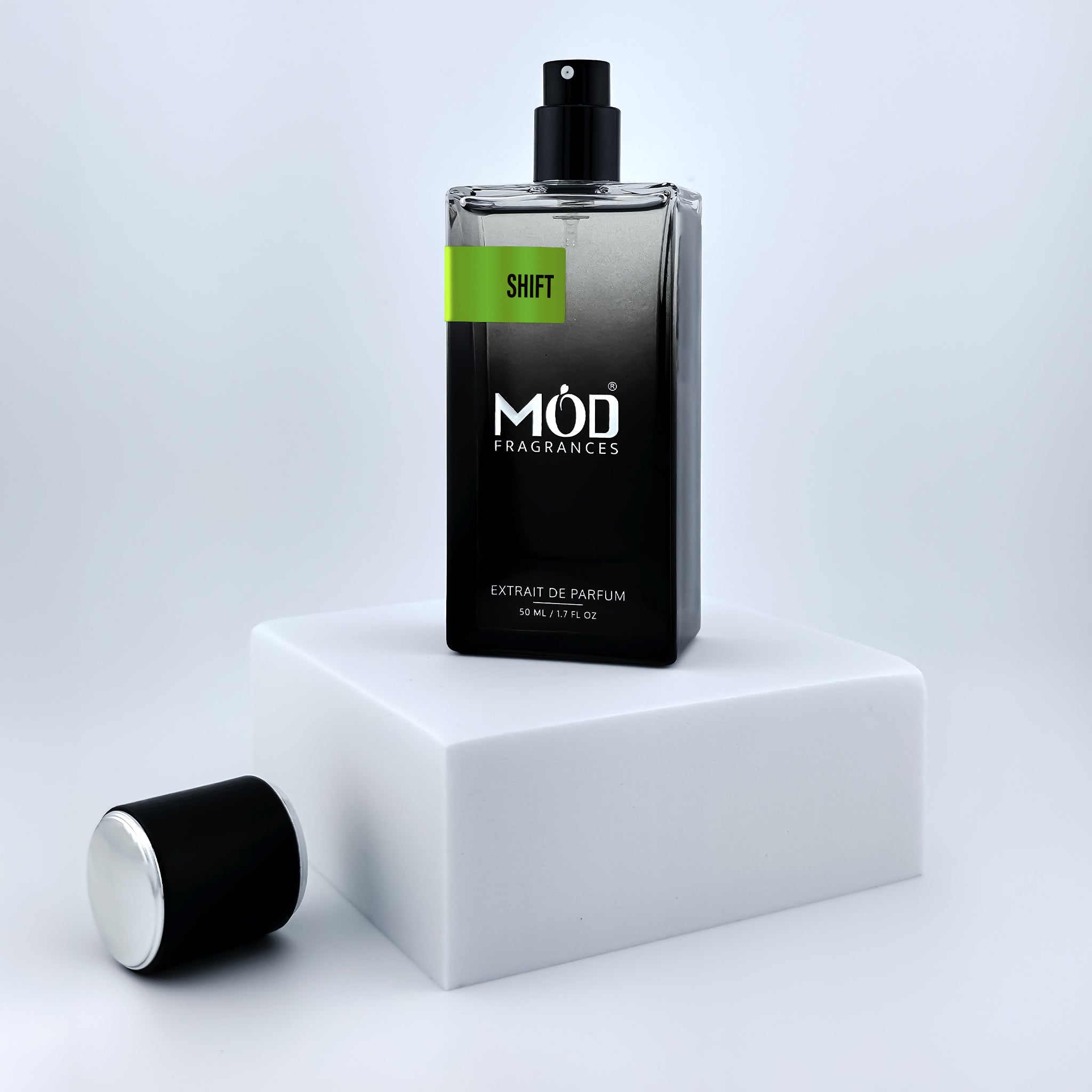 Black perfume bottle with 'Möd Fragrances' label on a white platform