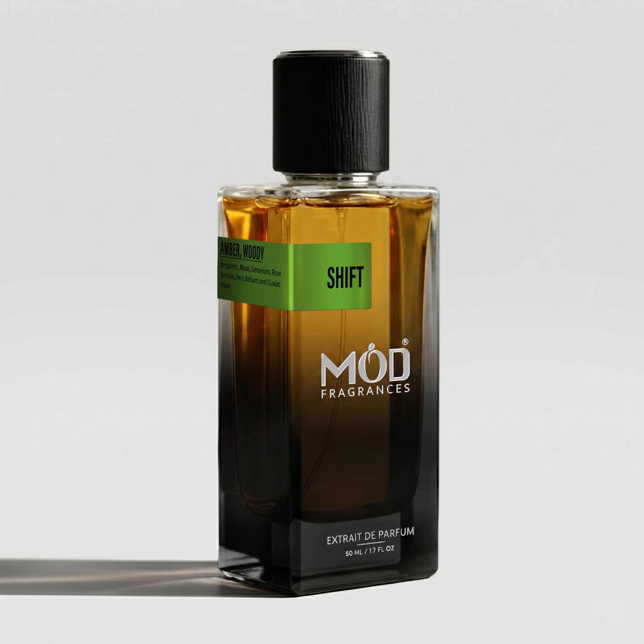 A rectangular glass perfume bottle by MOD Fragrances, labeled "Shift" with a small label detailing its leather, woody notes, stands on a light background.
