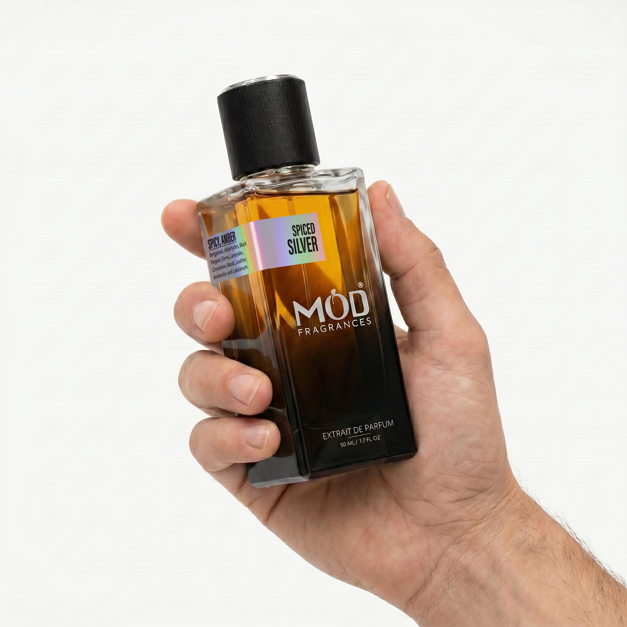 Hand holding a bottle of Spiced Silver MOD Fragrances on a white background