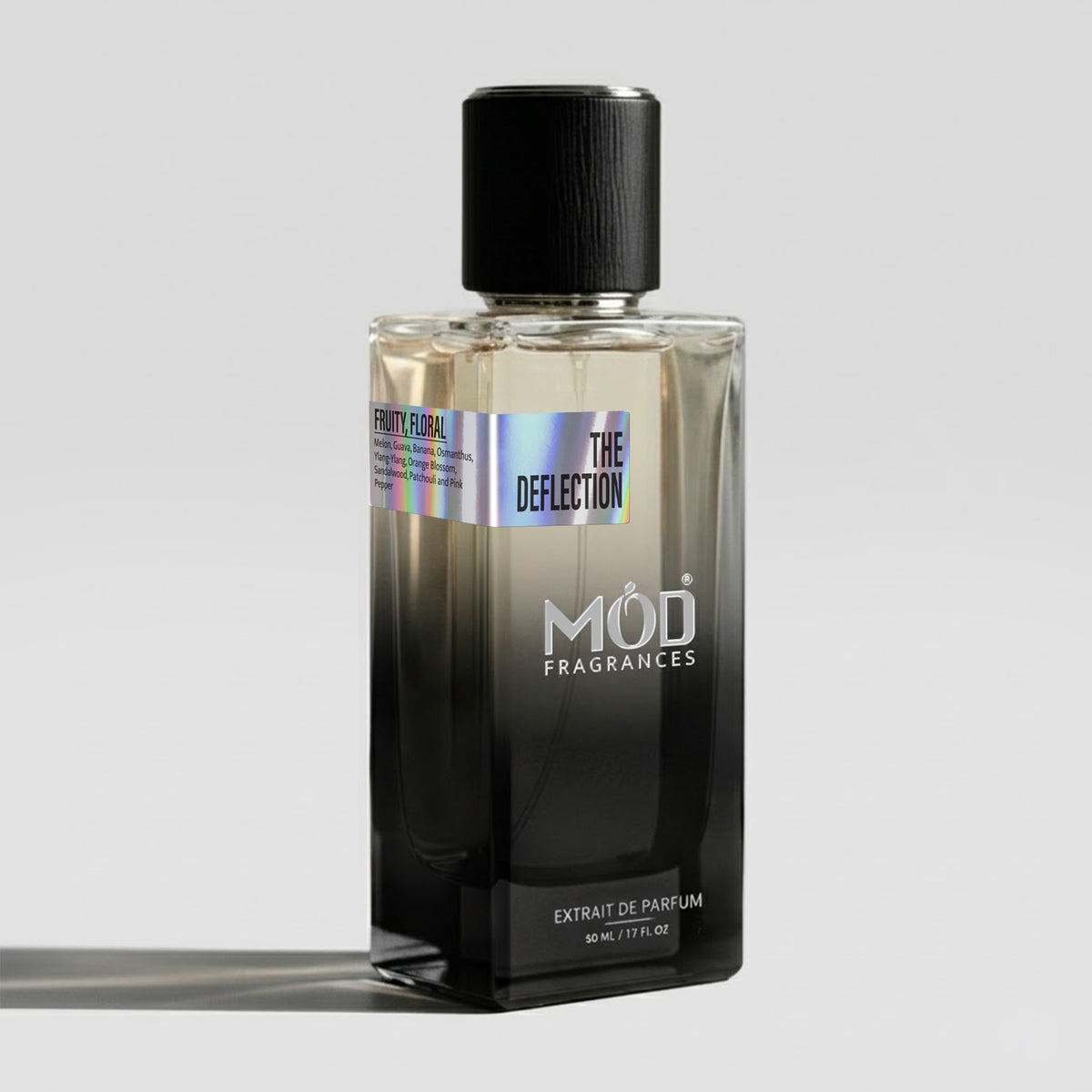 A bottle of Mod Fragrances 'The Deflection' Extrait de Parfum, featuring a black-to-clear gradient glass bottle with a textured black cap, set against a light gray background.