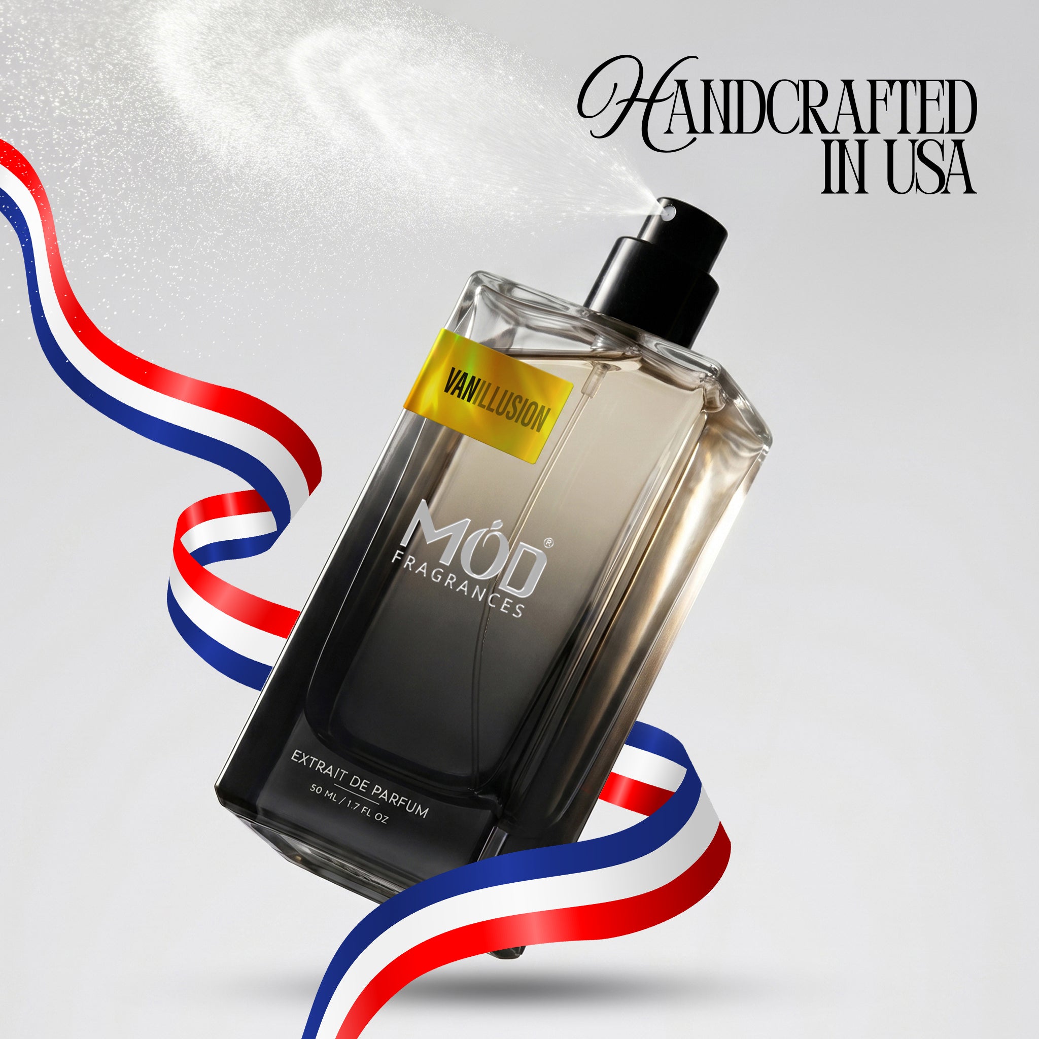 A bottle of Mod Fragrances Vanillusion 100ml Extrait de Parfum floating diagonally on a light gray background with a white spray mist. The bottle is clear glass showing a dark amber liquid inside, with a black spray nozzle and a yellow label.